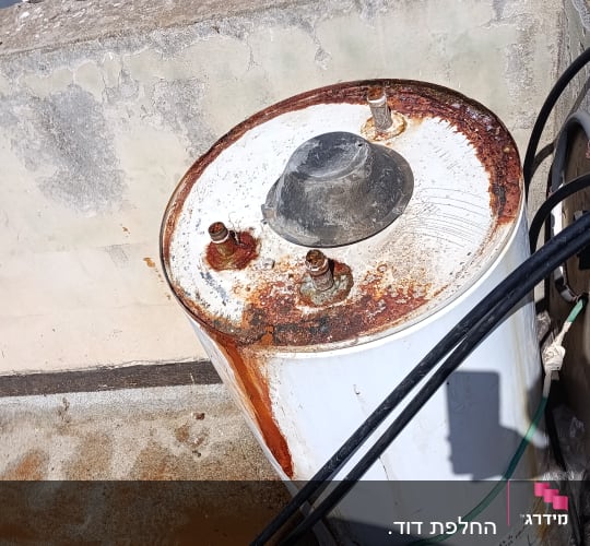 דוד שמש ישן עם חלודה על גג